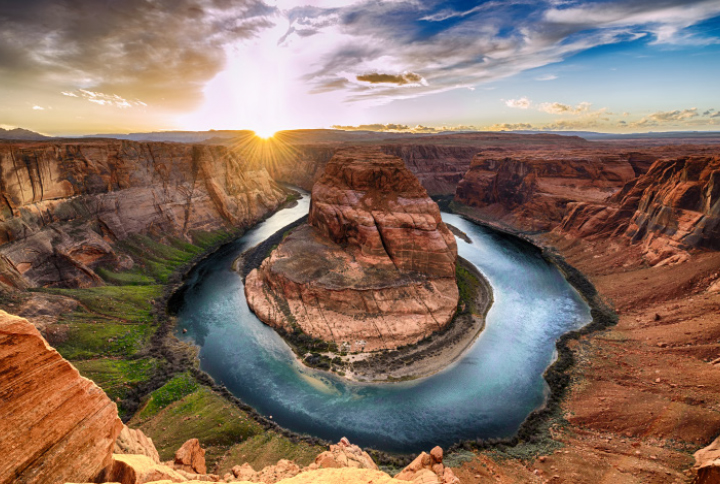 Horseshoe-shaped river bend beneath red desert cliffs